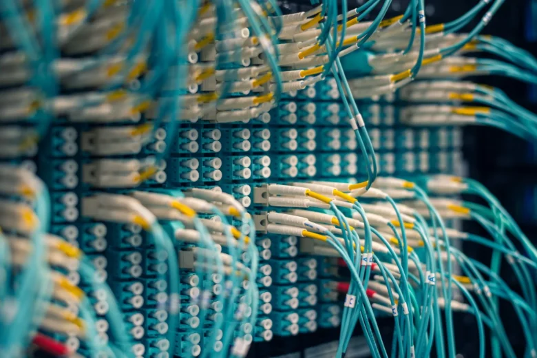 Rows of network cables in a data center representing the request path an LLM feature must travel end to end