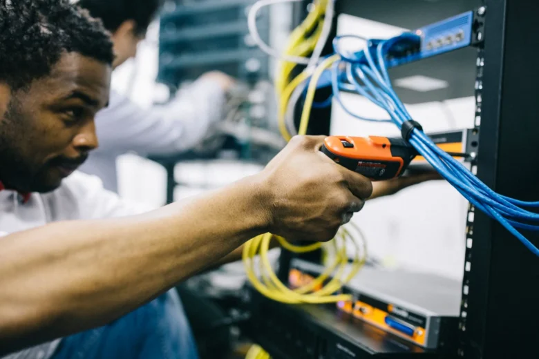 Engineer checking rack servers in a data center during scheduled maintenance